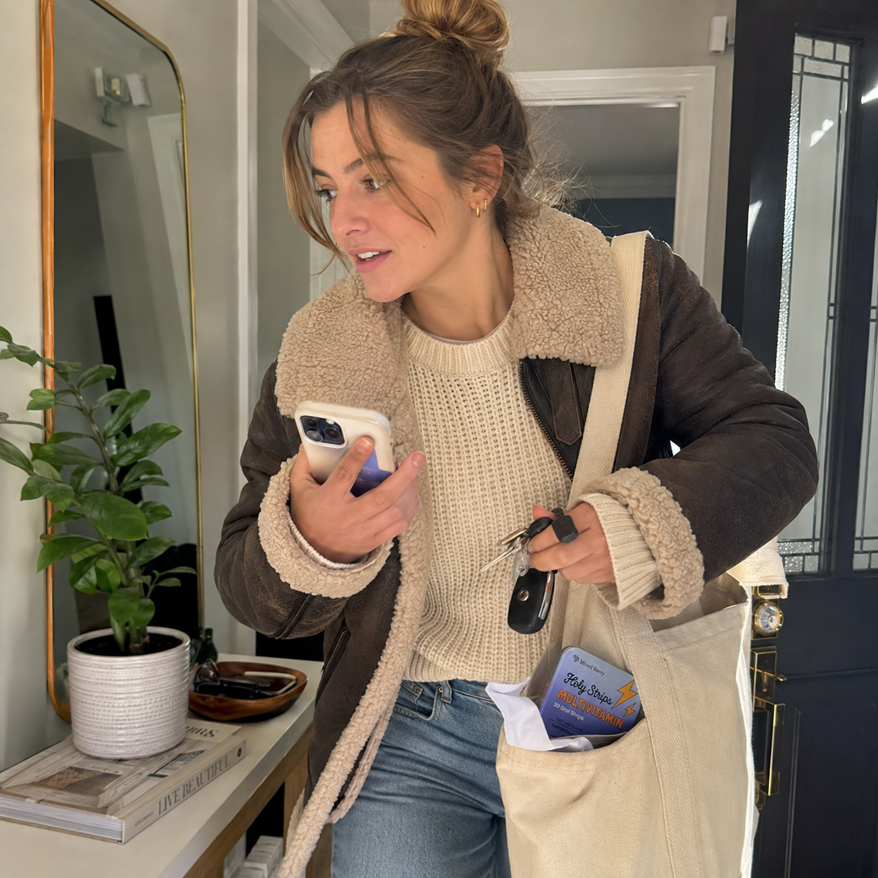 A woman rushing to get ready in soft daylight, keys and phone in hand, no time to sit down for breakfast.
