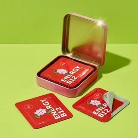 HolyStrips® Vitamin B12 vegan energy supplement strips rest on a green surface, with more inside an open metallic tin by Holy Strips.