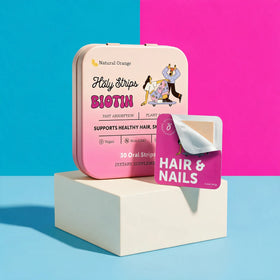 A box of HolyStrips® Biotin by Holy Strips, formulated for hair, skin, and nail support, rests on a pedestal with one fast-dissolving oral biotin strip partially peeled. The pink packaging features text and illustrations.